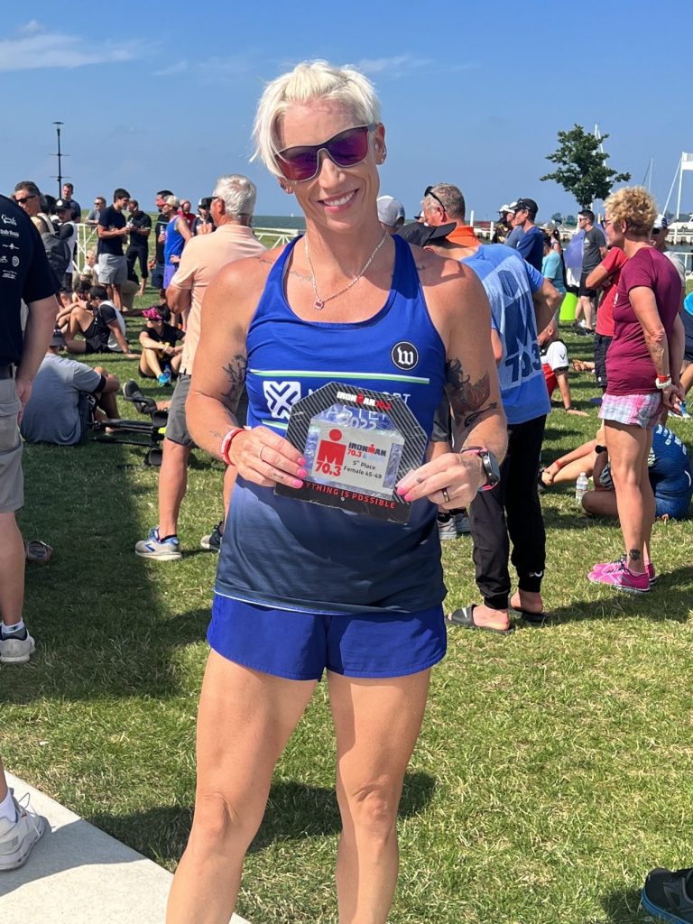 IMG_3178 Smiling triathlete holding an age group award at the finish area