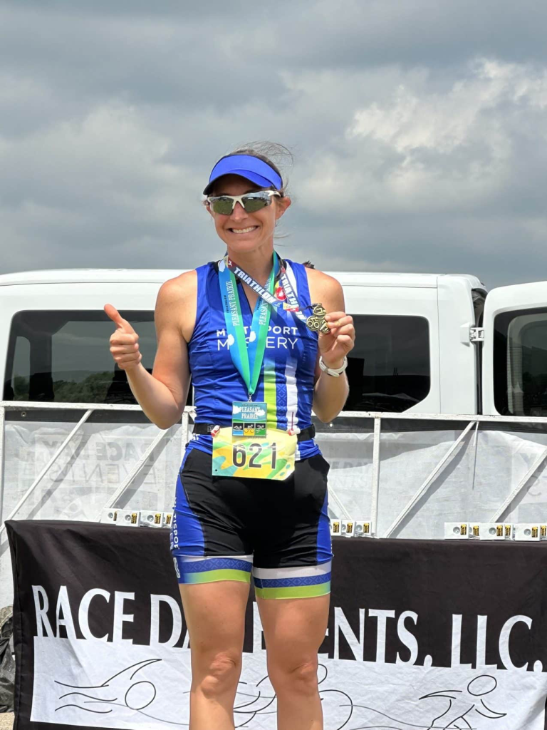 MultiSport Multisport Mastery athlete giving two thumbs up with her finisher medal