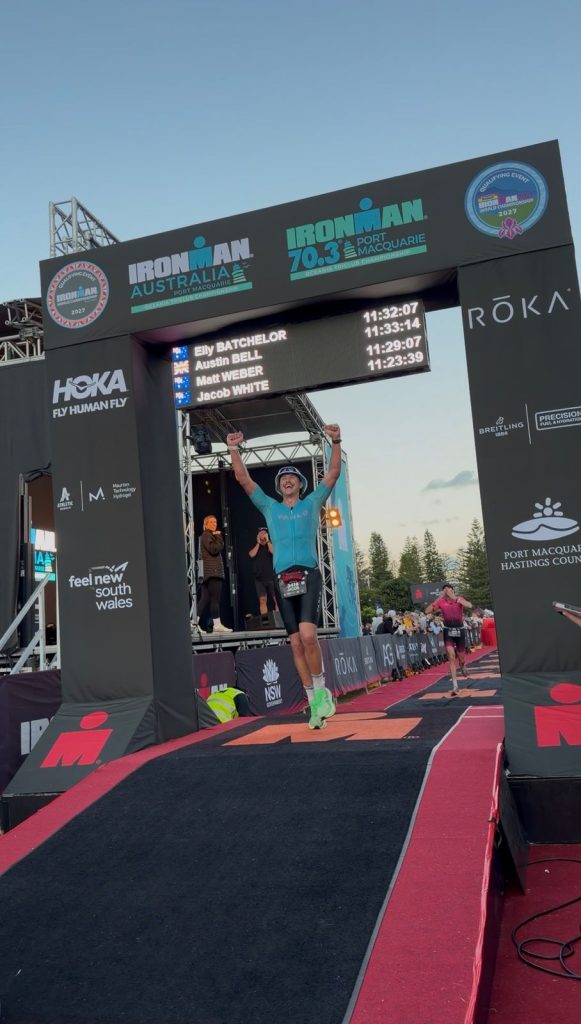 Jacob crossing the IRONMAN Australia finish line in Port Macquarie with his arms raised