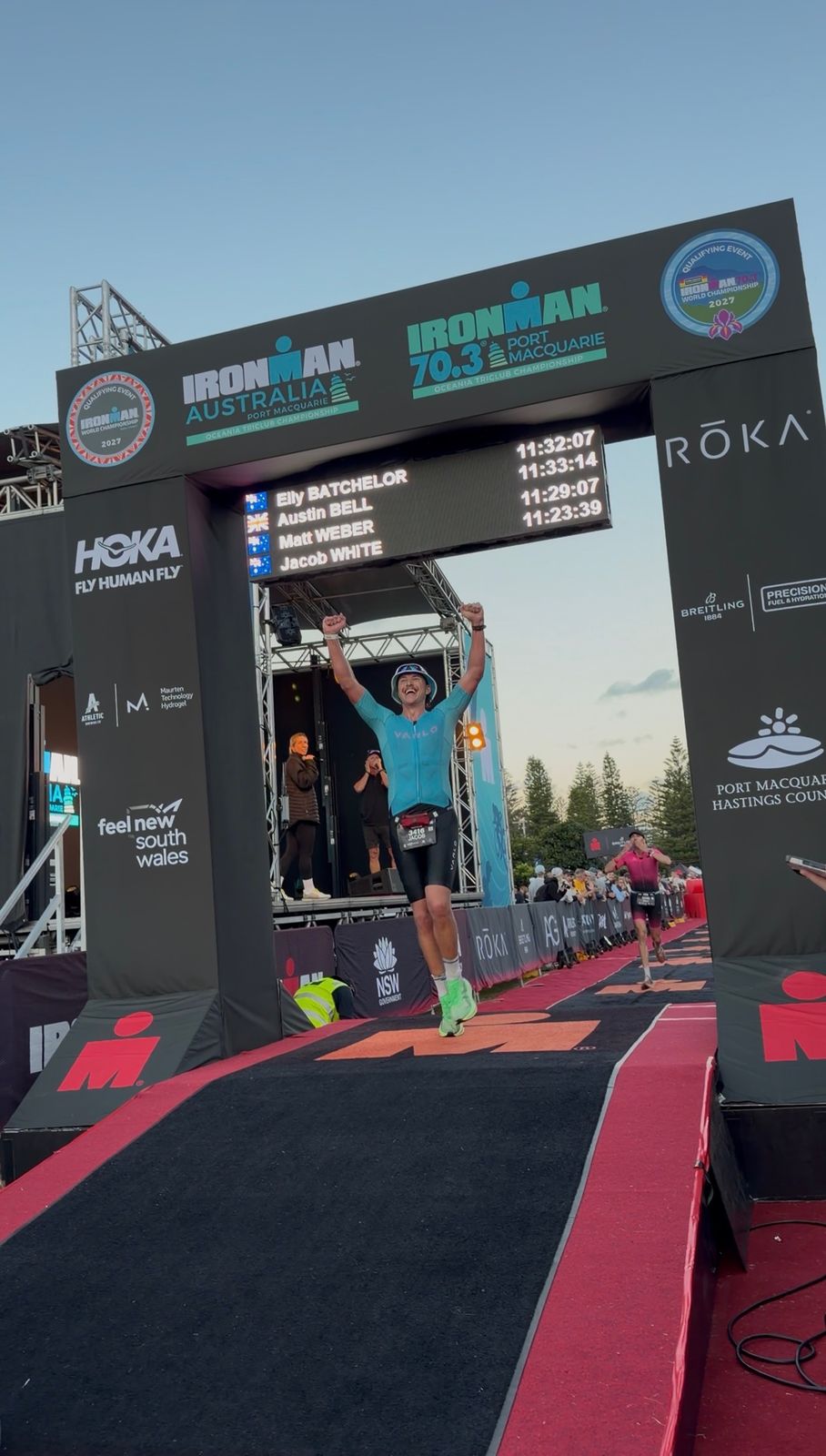 Jacob crossing the IRONMAN Australia finish line in Port Macquarie with his arms raised