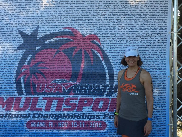 Kelly in front of the USA Triathlon Multisport National Championships banner in Miami