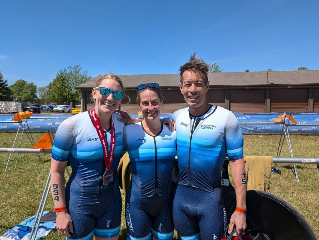 Three Multisport Mastery athletes in matching team kits in transition