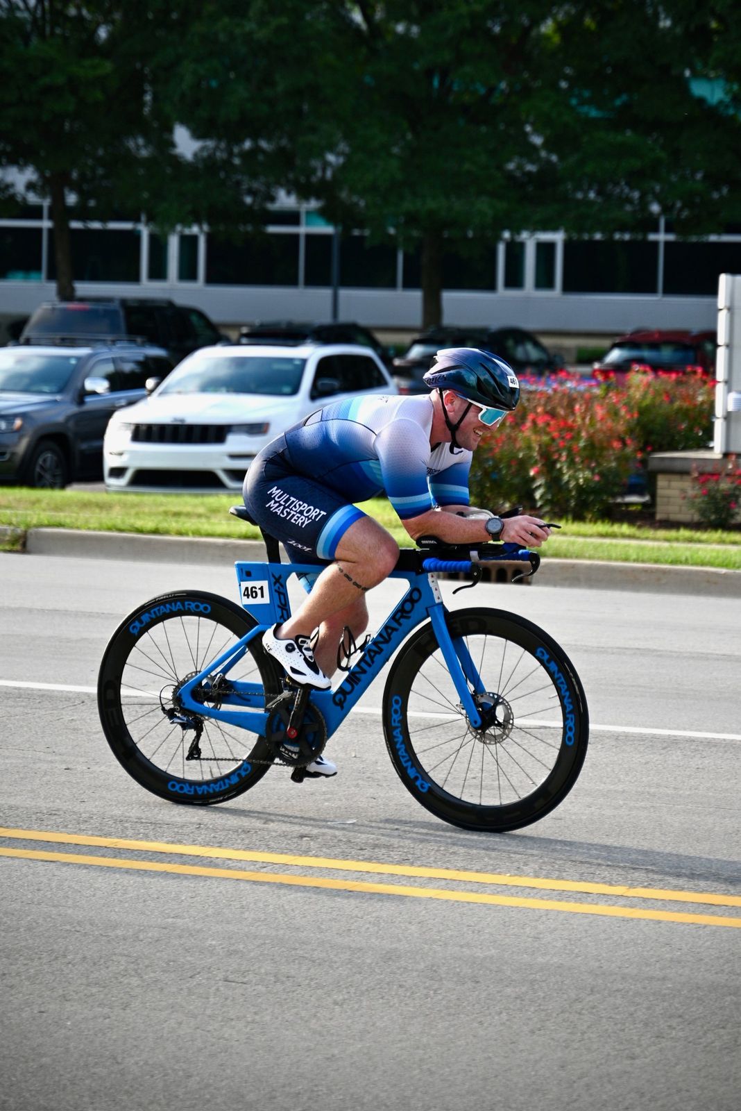 Triathlete in a Multisport Mastery kit riding a blue time trial bike in the aero position