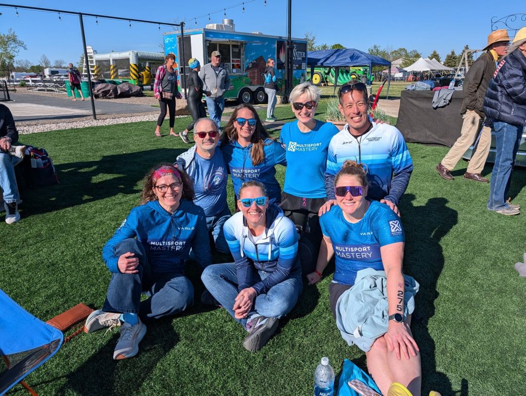 Multisport Mastery team members gathered on the grass after a race
