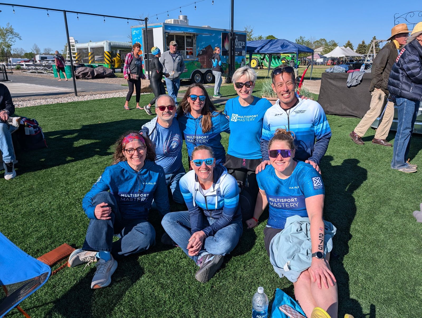 Multisport Mastery team members gathered on the grass after a race
