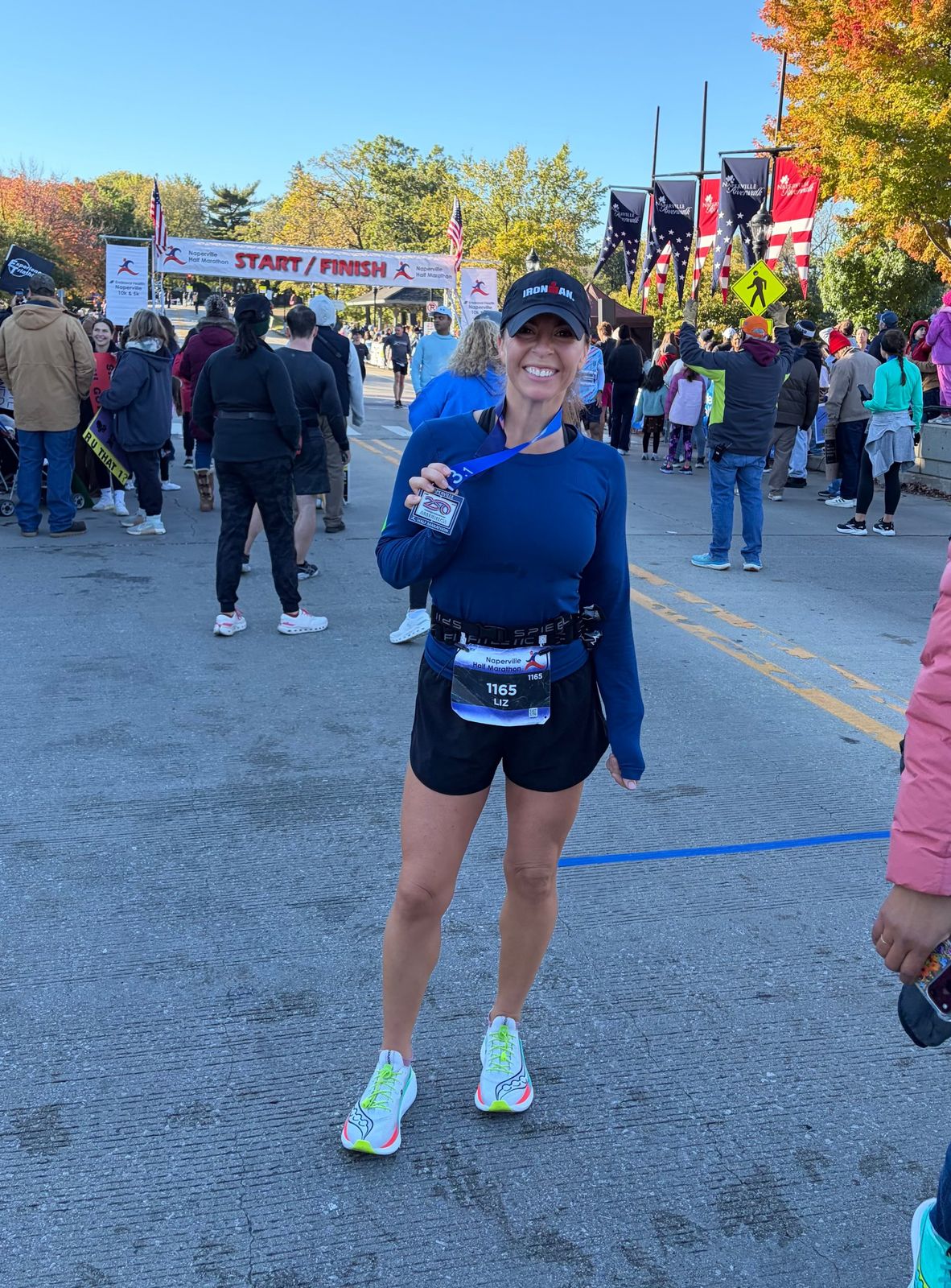 Runner smiling with her finisher medal at the Naperville Half Marathon finish
