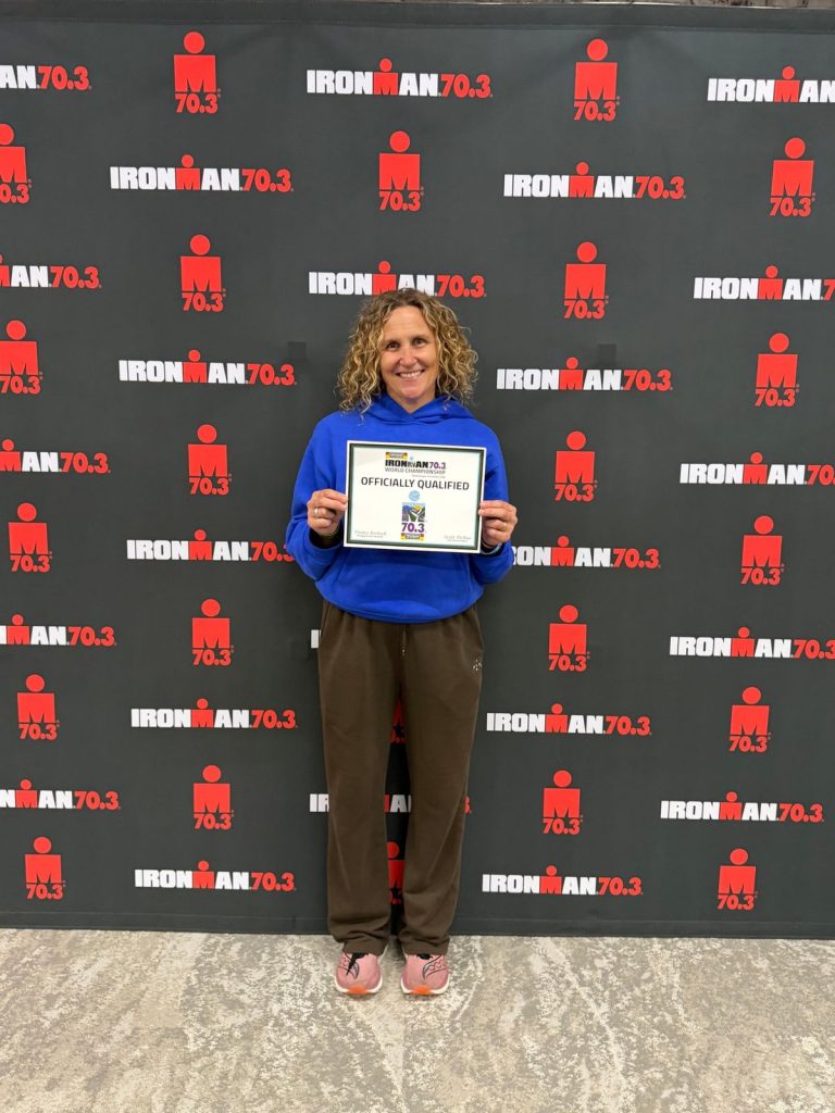 Athlete holding her IRONMAN 70.3 World Championship Officially Qualified certificate
