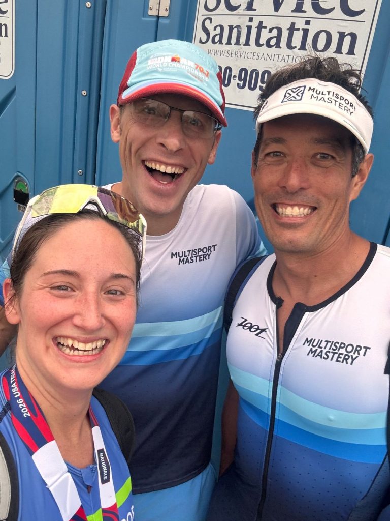 Three Multisport Mastery athletes grinning together on race morning